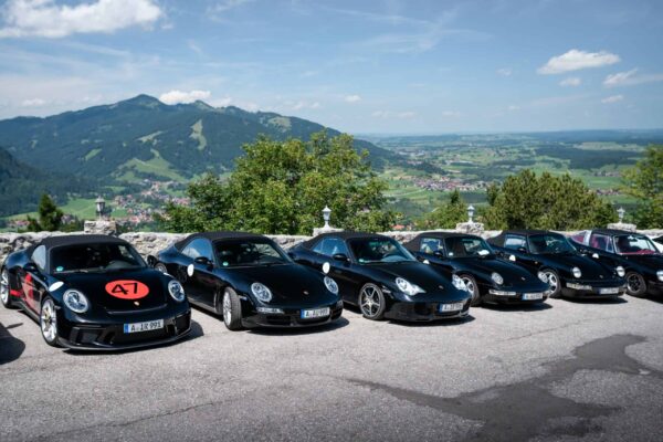 Porsche 911er stehen nebeneinander auf einem Parkplatz