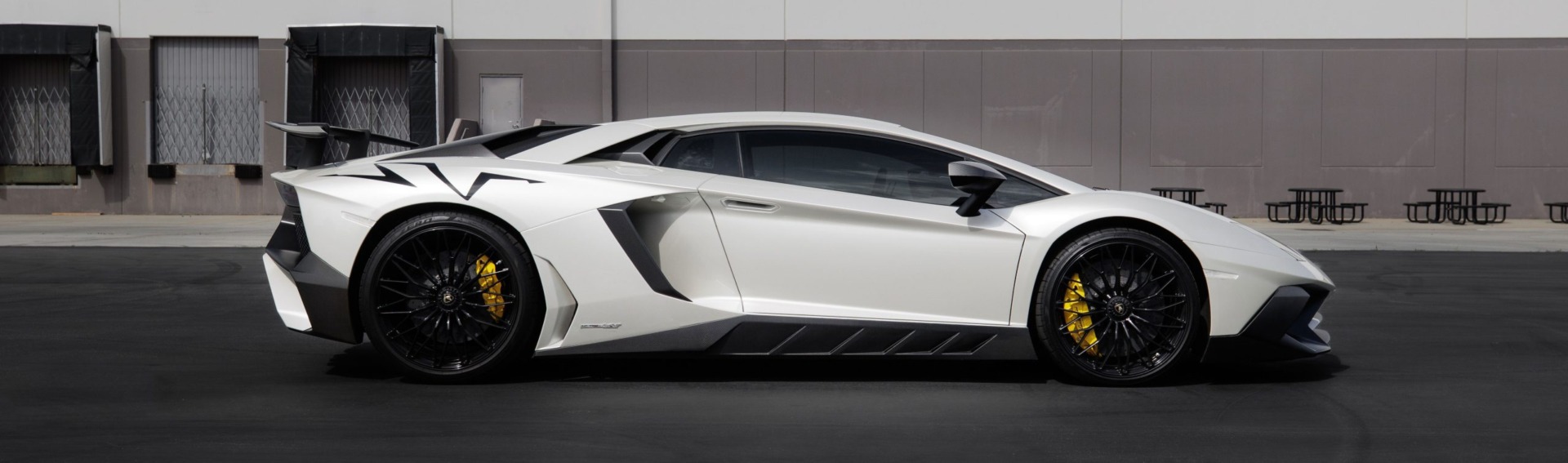 White Lamborghini standing in a parking area.